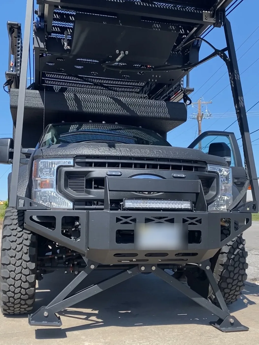 Front view of the tactical entry truck with stowed ladder platform and front outriggers planted